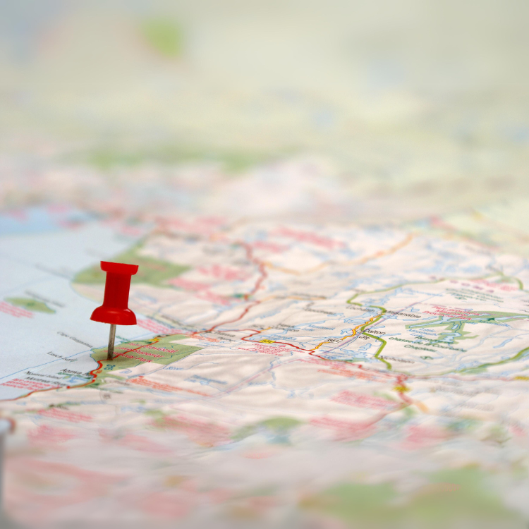 A map with a red pushpin stuck in a location.
